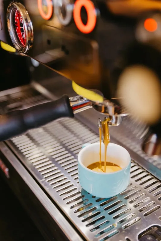 Espresso pouring into a blue ceramic cup