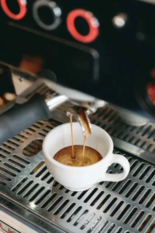 Espresso pouring into a white cup
